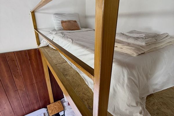 El entrepiso ofrece una cama individual con vista al resto de la habitación, creando un espacio tranquilo y original para descansar gracias a su diseño de doble altura.