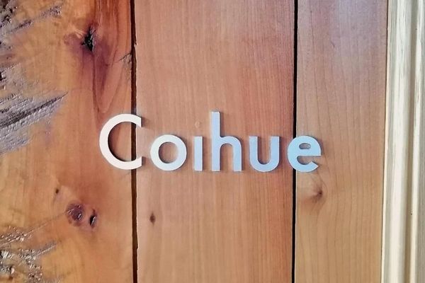 Cartel de la habitación Coihue en la hostería Wesley, con letras en relieve sobre madera rústica