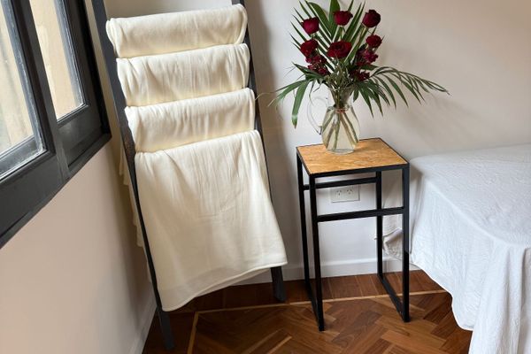 Dormitorio amplio con cuatro camas individuales, ideal para viajeros que buscan compartir. Ambiente luminoso y sereno, con detalles simples y funcionales. El piso de madera aporta calidez, mientras que la luz tenue crea una atmósfera tranquila.