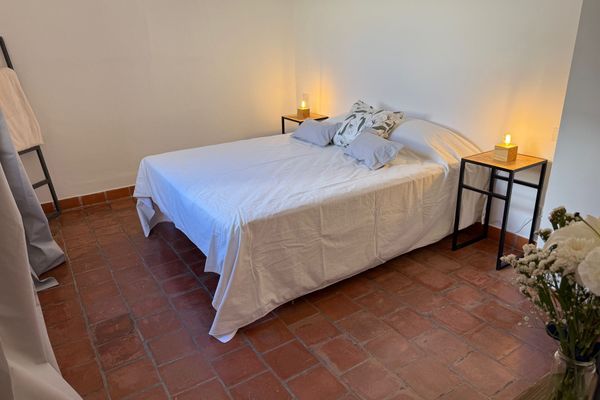 Dormitorio con cama queen, aire acondicionado y luz natural. Ideal para descansar en un ambiente simple y cómodo.