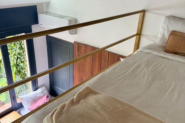 El entrepiso ofrece una cama individual con vista al resto de la habitación, creando un espacio tranquilo y original para descansar gracias a su diseño de doble altura.