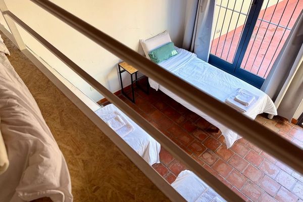 Perspectiva desde el entrepiso que muestra la distribución de las camas y la conexión con la terraza privada. Un espacio cómodo, ideal para relajarse y disfrutar del aire libre.
