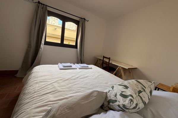 Dormitorio con cama queen, aire acondicionado y luz natural. Ideal para descansar en un ambiente simple y cómodo.